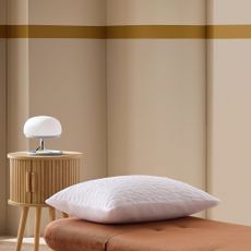 Habitat Benji Chair Bed with a white pillow on top and a round wooden bedside table with a white lamp