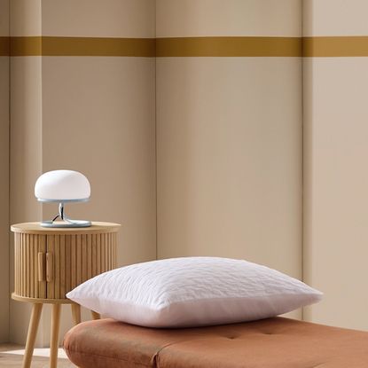 Habitat Benji Chair Bed with a white pillow on top and a round wooden bedside table with a white lamp