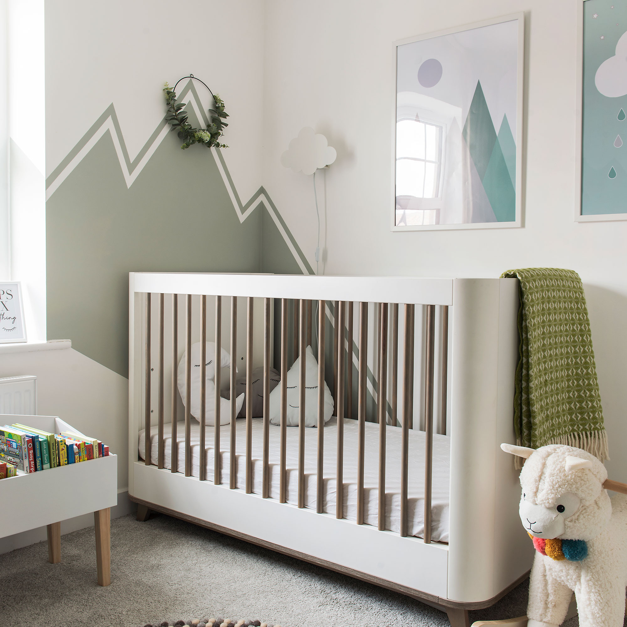 Nursery with green paint effects on wall behind crib