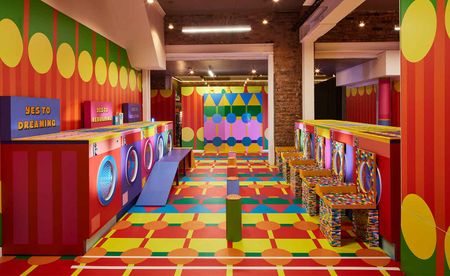 Interior view of Yinka Ilori's Launderette installation featuring mock washing machines in bright colours