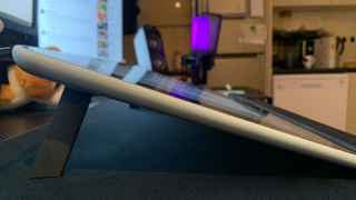 The side-view of a Wacom One on a desk with its retractable legs extended