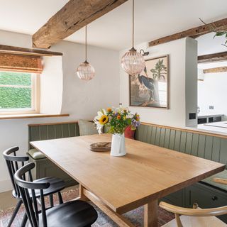 green banquette seating with oak table and black and oak wishbone chairs