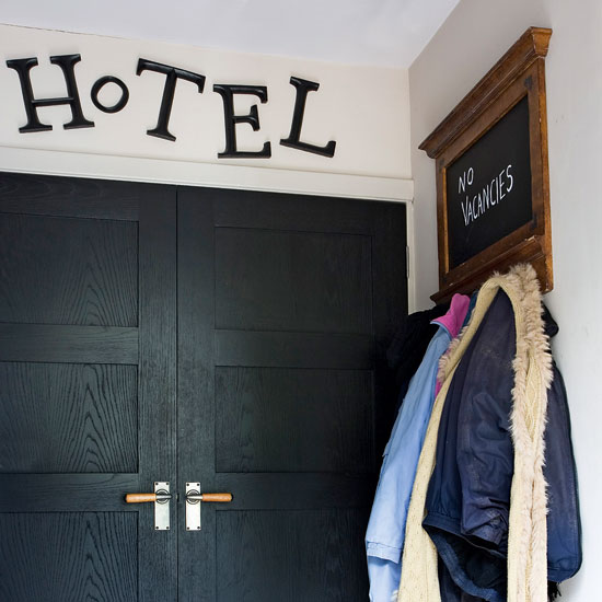 hallway area with black door and hung clothes