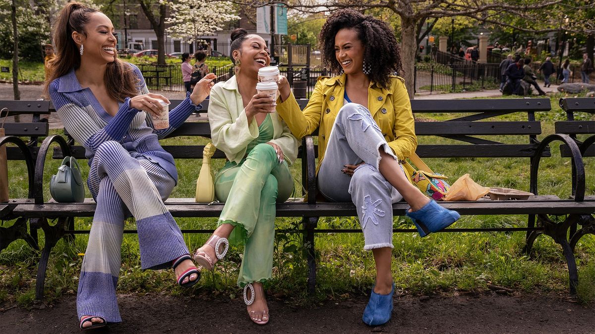 Amber Stevens West, Bresha Webb and Corbin Reid as Whitney, Renee and Sondi laughing on a park bench in Run the World season 2