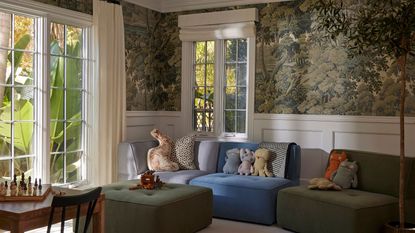 playroom with leafy mural and colored sectional with animal cushions