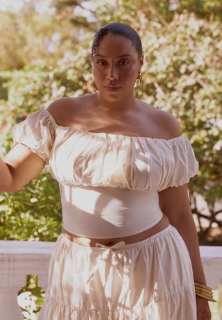 model ears off shoulder white top with white skirt outside 