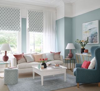 Living room with blue walls, patterned blinds and white sofa