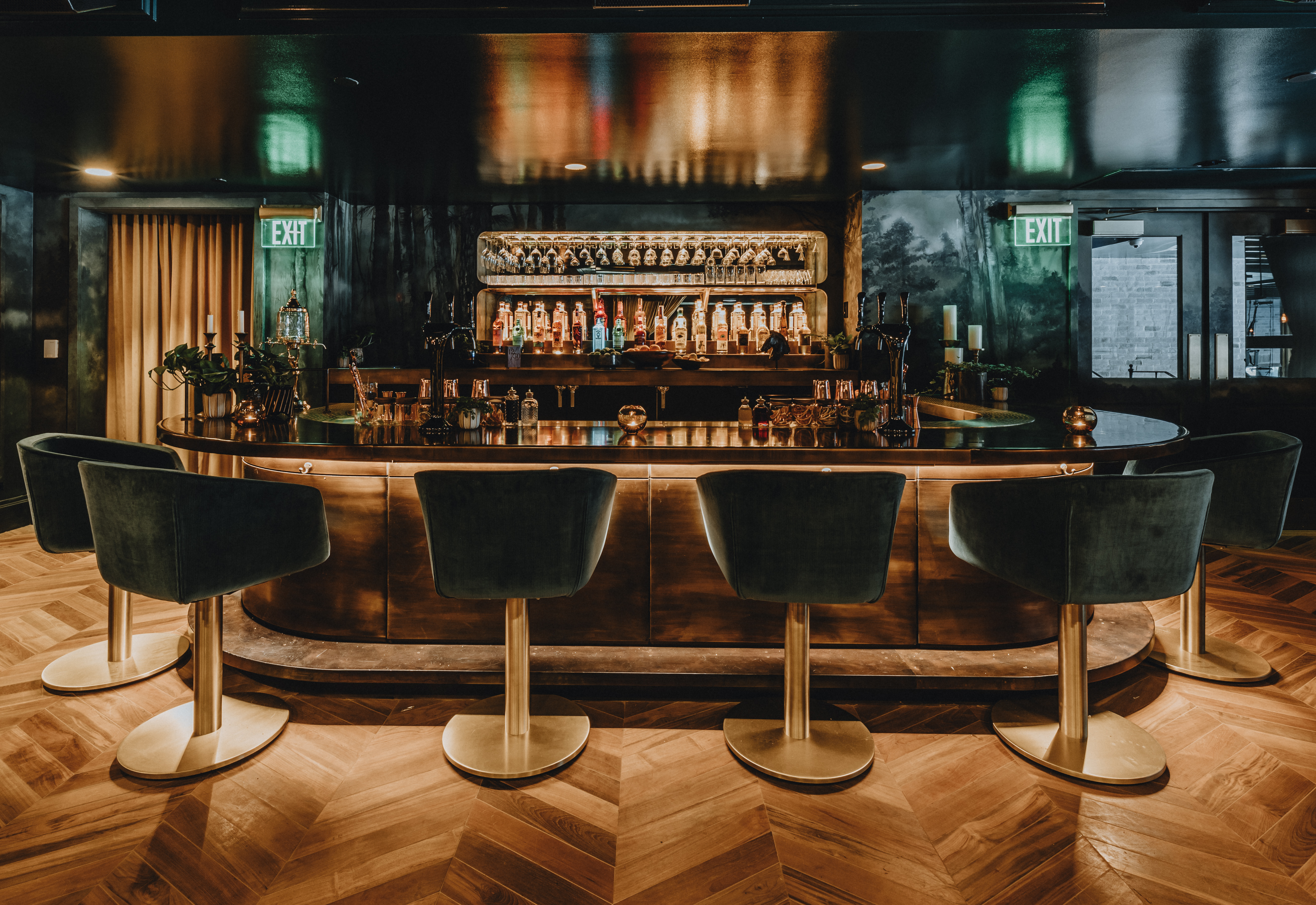 A glittering bar with dark green upholstered seats