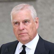 Prince Andrew grimacing in a dark suit