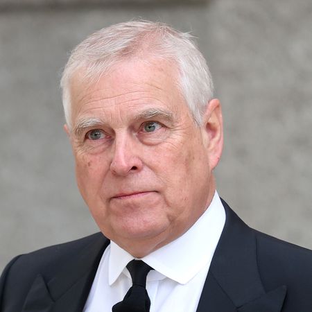 Prince Andrew grimacing in a dark suit