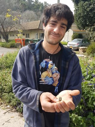 Dekel Ben-Shitrit holds the bronze ring he found while weeding in a garden.