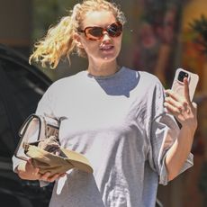 Elsa Hosk in Los Angeles heading to a Pilates class in an oversized T-shirt, tan leggings, and tan leather Chanel flip-flops. 