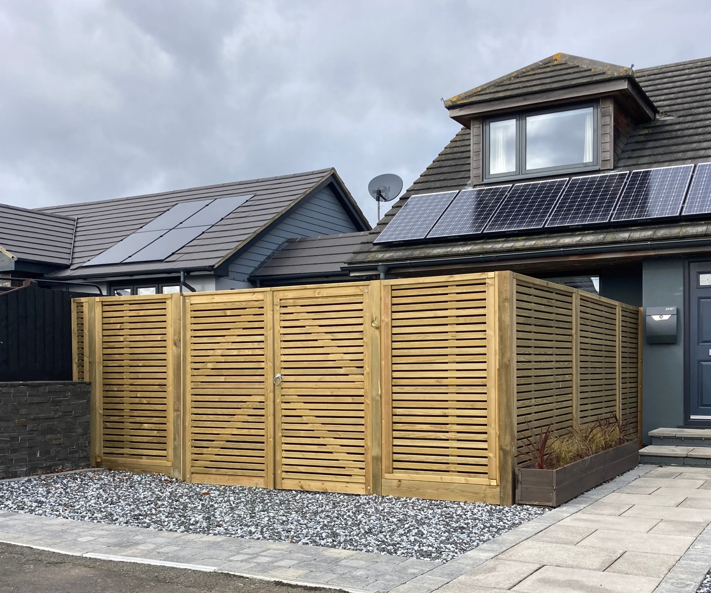 modern venetian style fencing with double gates built around small gravelled driveway area