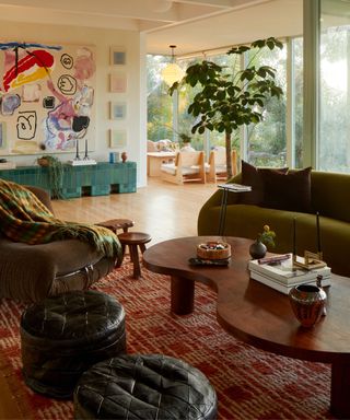 eclectic colorful living room with olive green couch and a large piece of artwork over a tiled bench