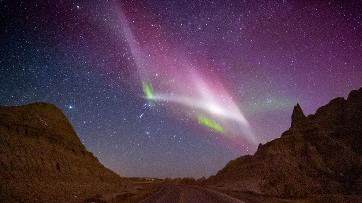 streaks of white and green stretch across the night sky