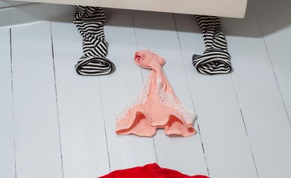 Socks and women's underwear on a floor in the shape of a face- eyes, nose, mouth