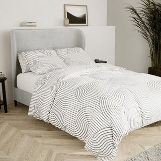 grey velvet bed frame with white and black bedding