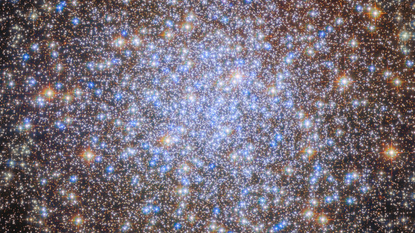 A cluster of brilliant white and golden stars shines in the darkness of space.