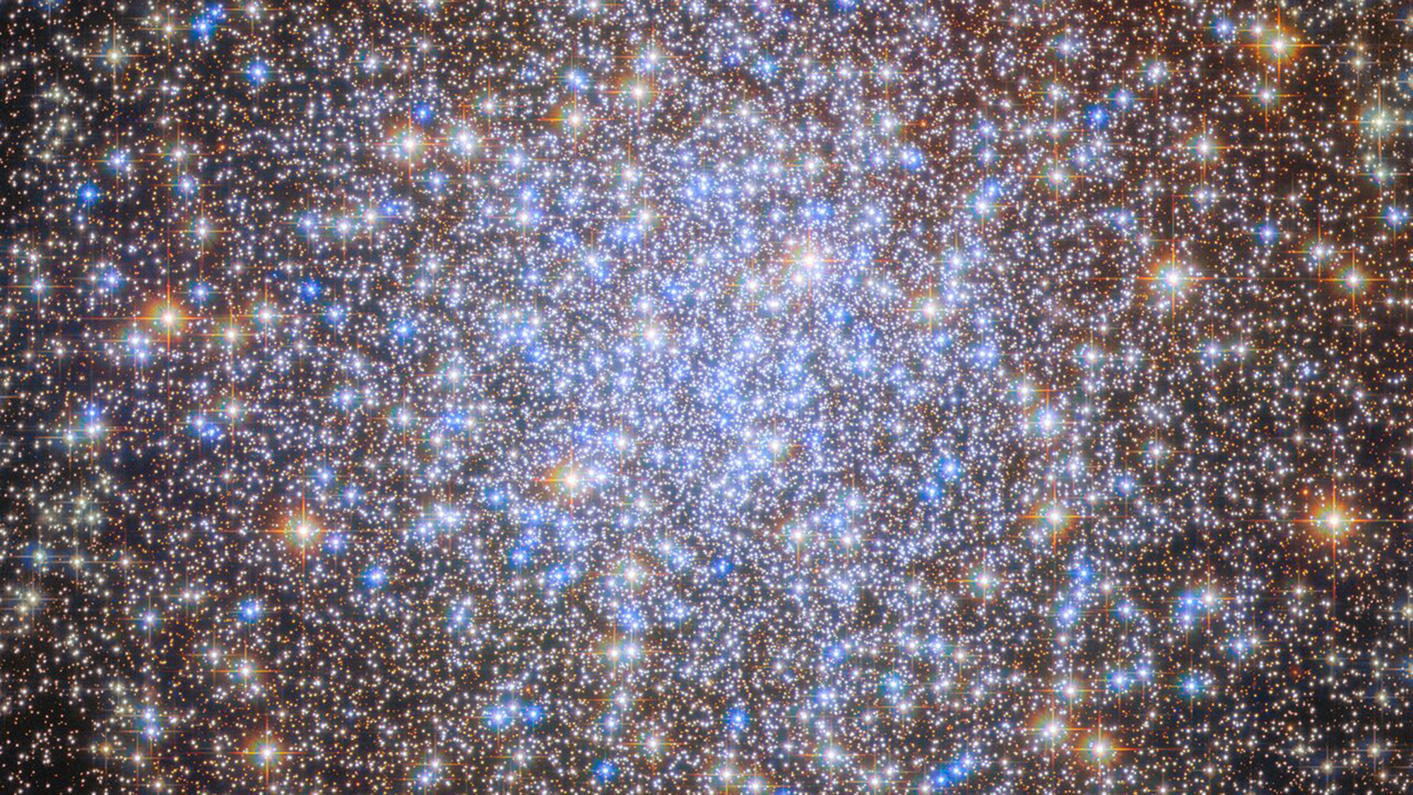 A cluster of brilliant white and golden stars shines in the darkness of space.