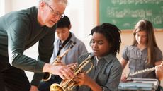 Teacher and students preparing to play musical instruments 