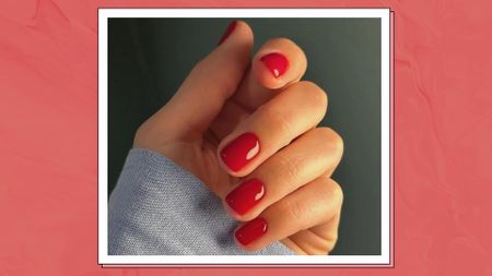 A hand with red nails, courtesy of @matejanova, for a piece on red nail designs/ in a muted red, marbled template