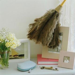 framed photographs on side table with large duster