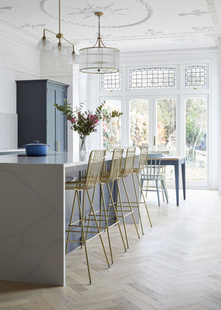 waterfall edge counter in a old fashioned room with ceiling details and white walls