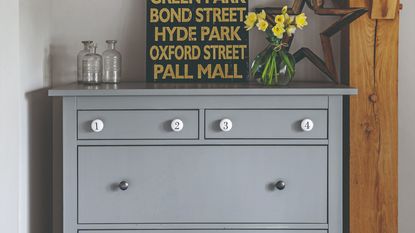 A chest of drawers with flowers and decor on top