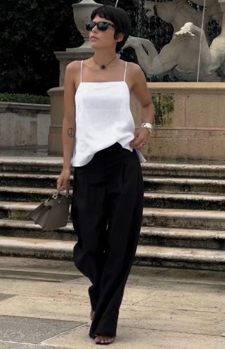 Woman in white top and black pants.