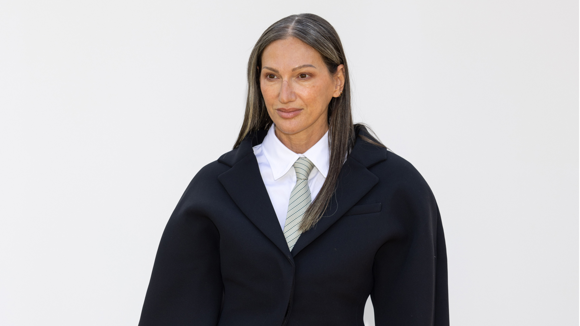 Jenna Lyons wearing her hair down and straight and wearing a button up shirt and tie with a blazer over it.