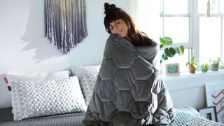 Woman wraps a Layla Weighted Blanket around herself