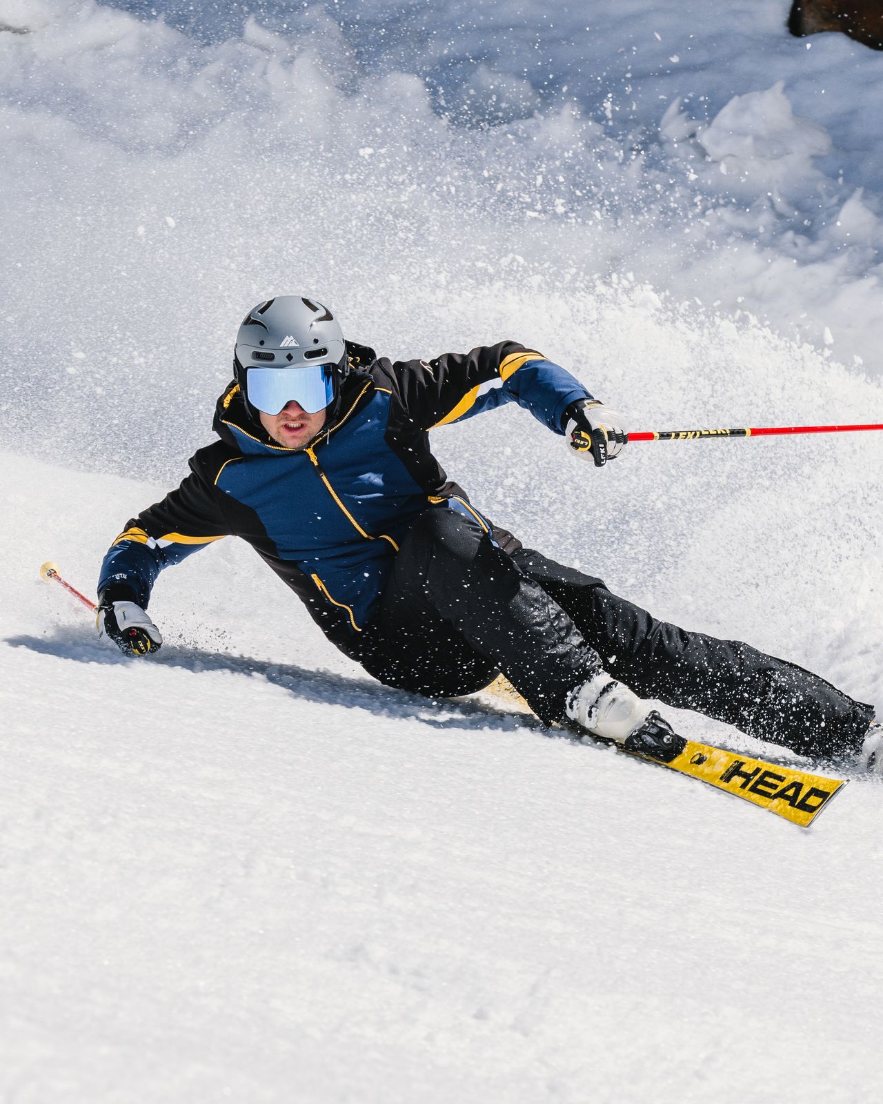 A man skiing downhill with a helmet on