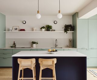 A light blue and dark blue kitchen with matching colored handles