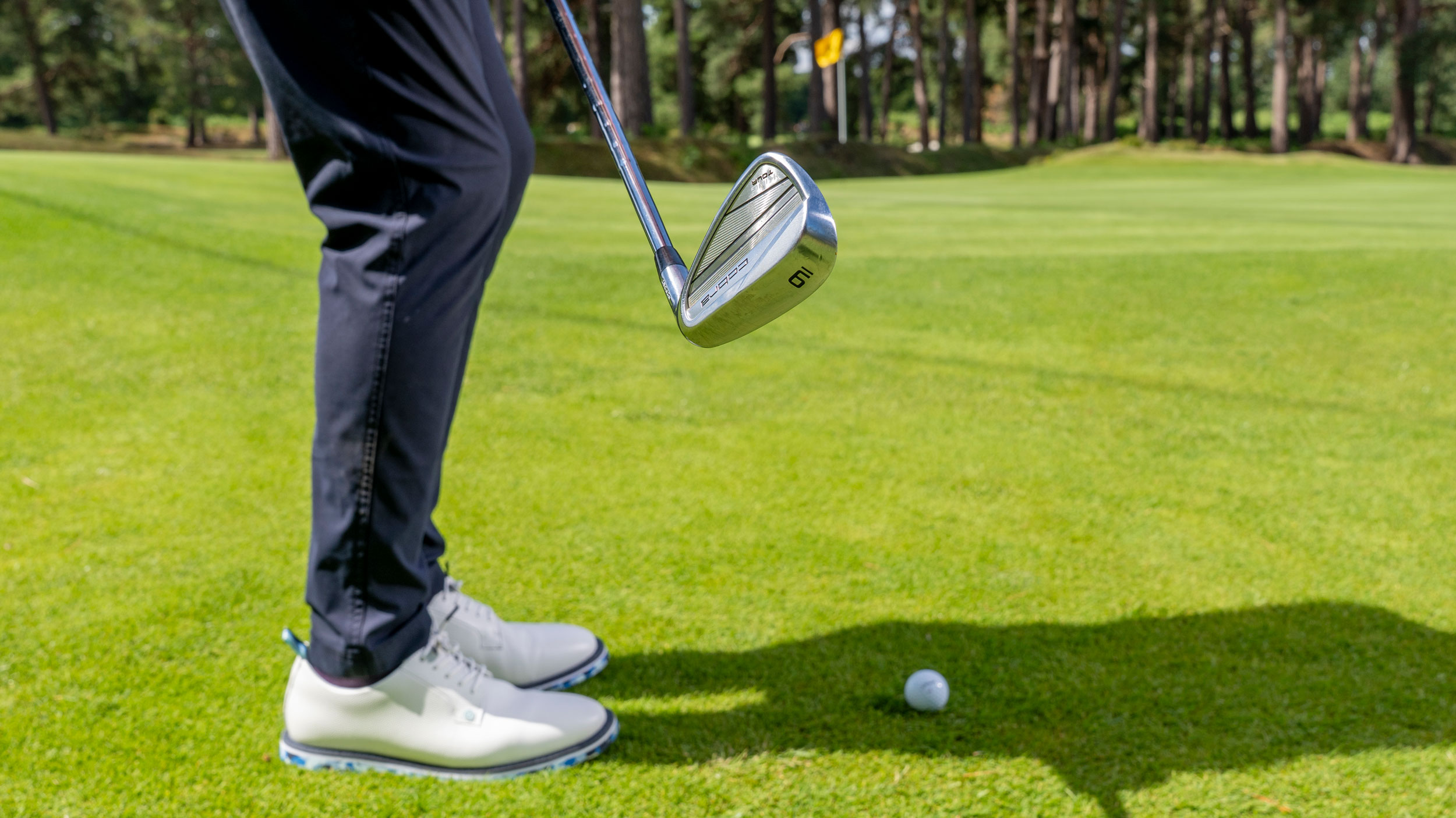 Golfer chipping with a 9-iron