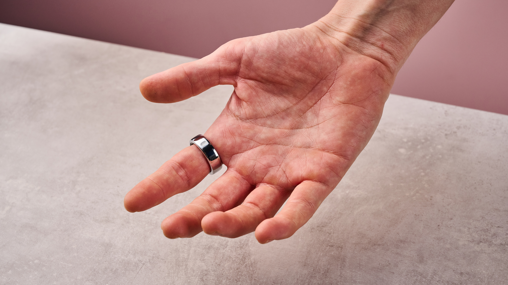 The Oura Ring 3 on a man's index finger, showing the palm side.
