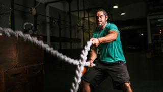 Man exercising with battle ropes