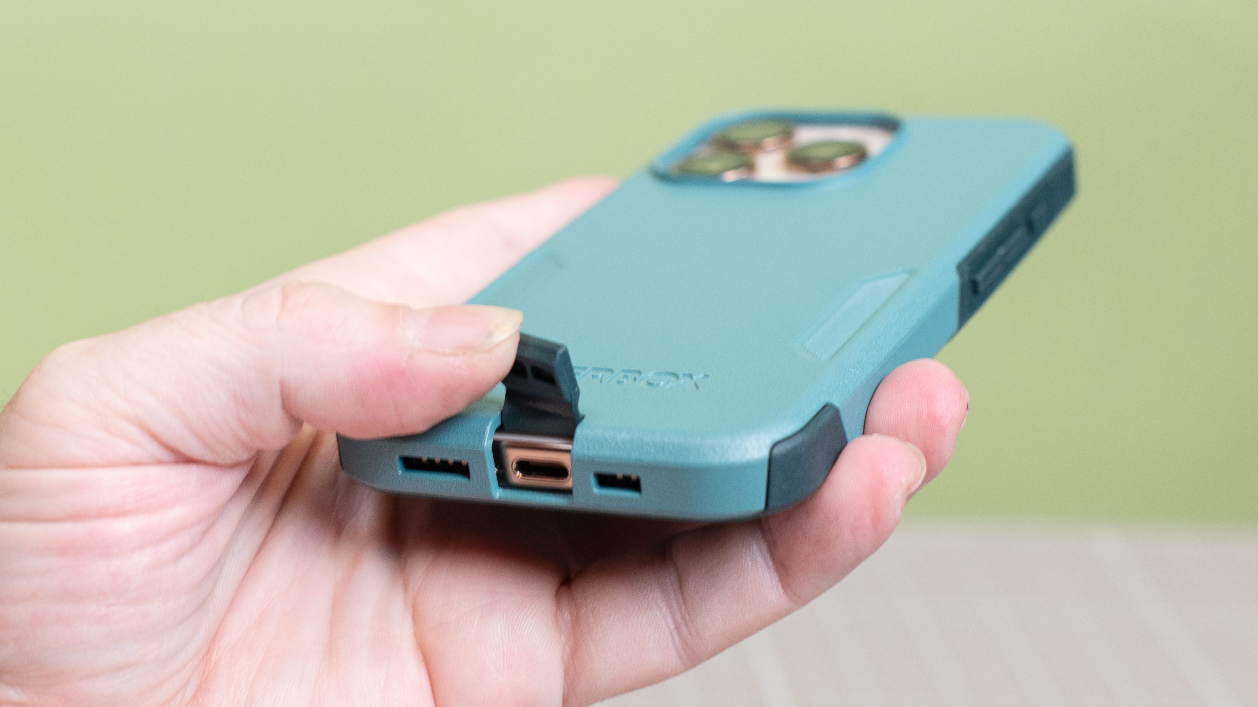 Otterbox Commuter Series from bottom showing covered USB-C port open held open by finger