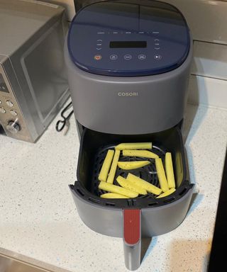 Raw potatoes sliced as fries in Cosori Lite air fryer appliance