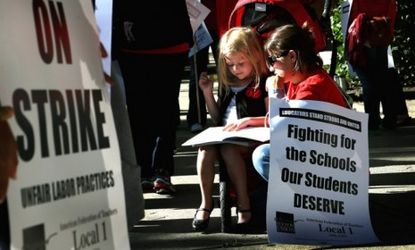 Jillian Connolly helps her daughter with math while picketing during a teachers strike in Chicago on Sept. 10.