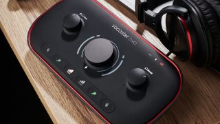 A Focusrite Vocaster Two audio interface on a desk with a microphone