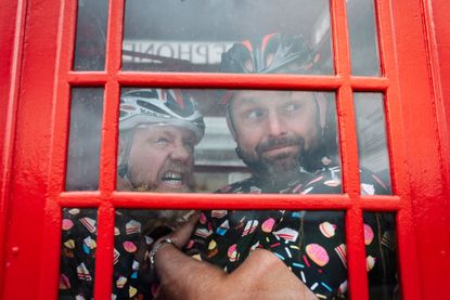 Two cyclists in a phone box