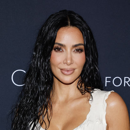 kim kardashian has glossy wet-look curls and a bronze makeup look