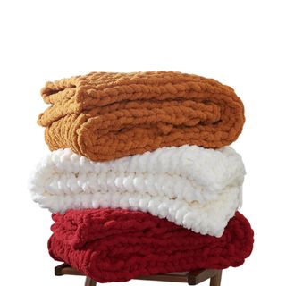 A stack of three fall colored blankets