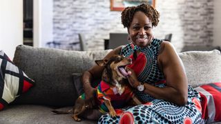 Woman sat on couch with her dog