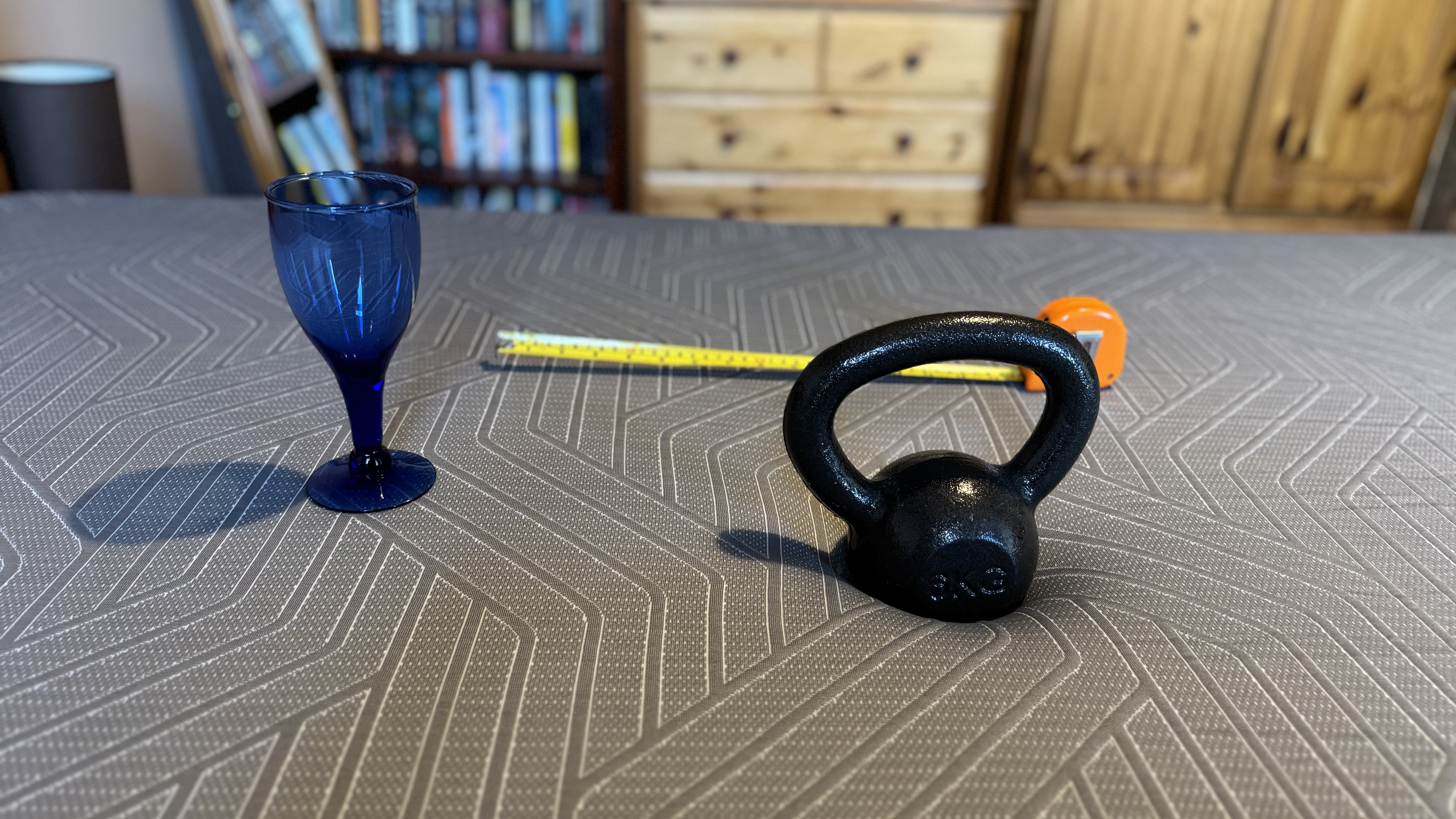 A wine glass, tape measure and weight to measure motion transfer on the EGOHOME Hybrid mattress.