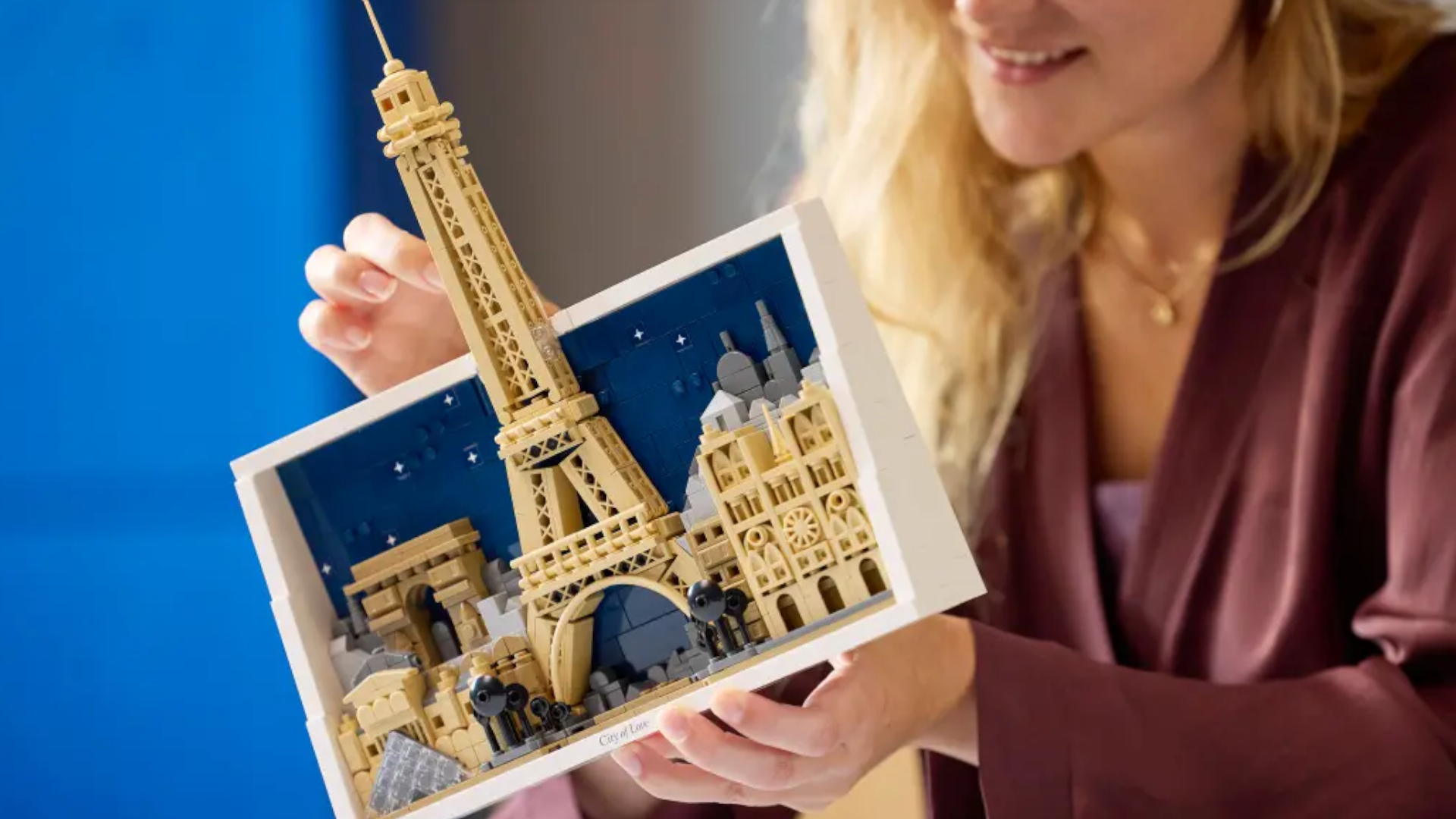 A smiling woman holds the Lego Paris - City of love kit in her hands