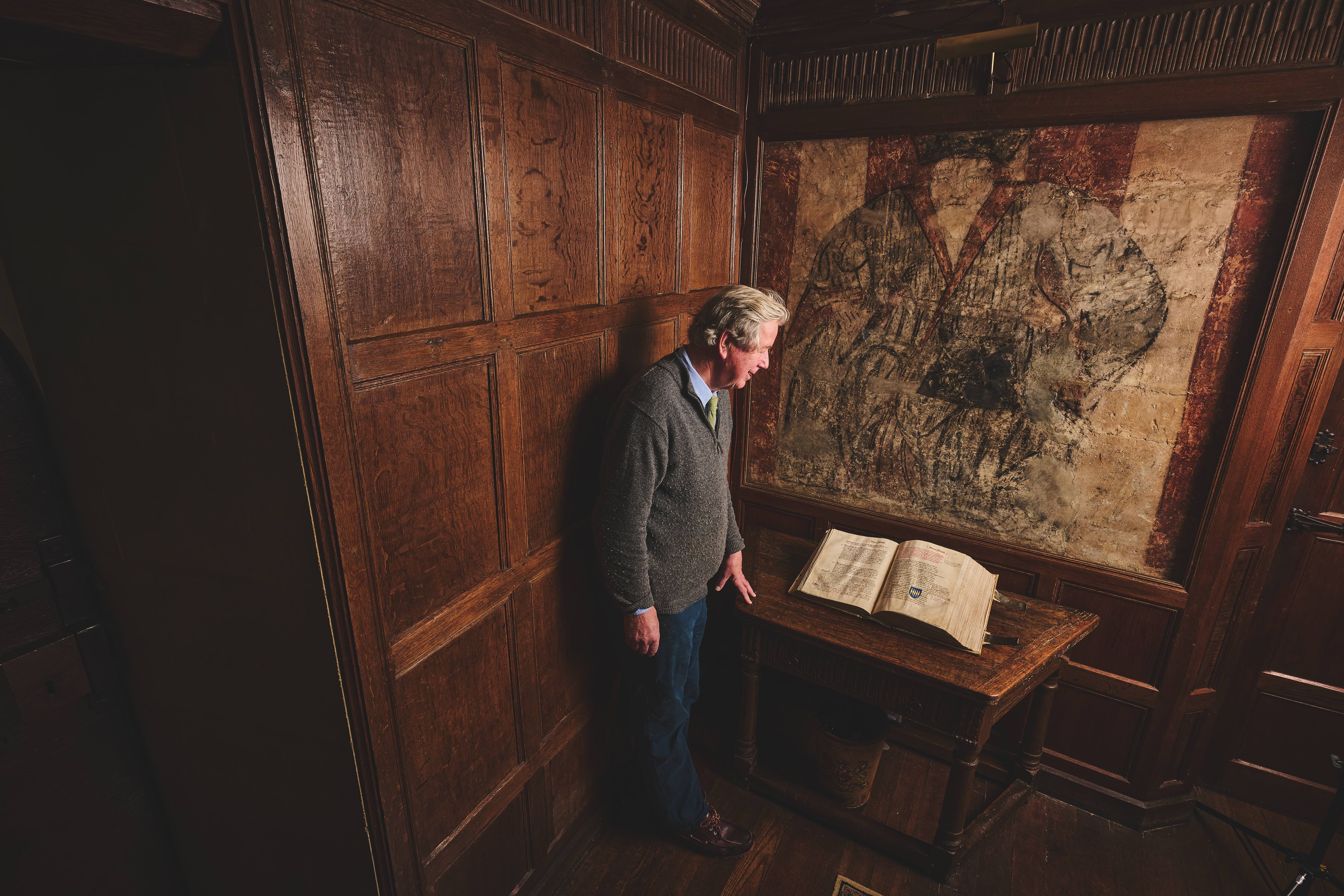 Country House Treasures at Great Chalfield. Cartulary (15th century property portfolio) in front of the wall painting of Thomas Tropenell MP who built the house in 1470.