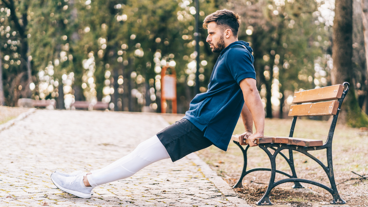 Man doing tricep dips on a park bench