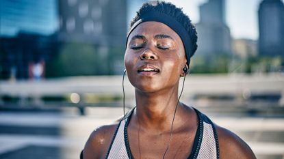 Sweaty woman working out with earphones