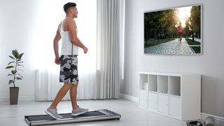 Man uses one of the best walking treadmills in his home